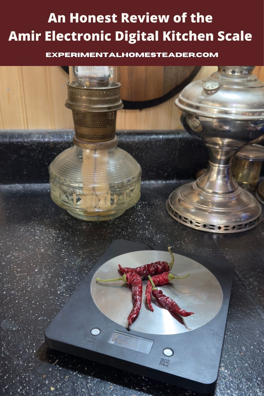 A cozy kitchen scene with a digital kitchen scale on a black countertop. Dried red chili peppers sit on the scale. In the background, vintage glass and metal oil lamps add a rustic homesteading vibe.