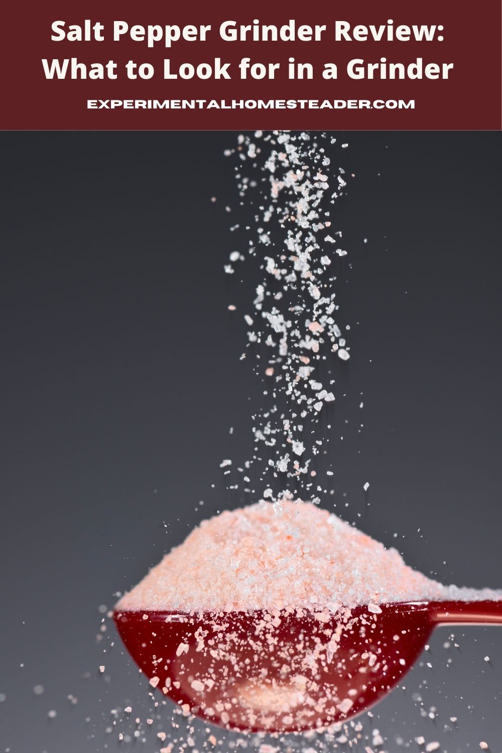 Pink Himalayan salt pouring into a red measuring spoon against a dark background, highlighting freshly ground salt.