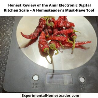 A digital kitchen scale with dried red chili peppers placed on its stainless steel surface.