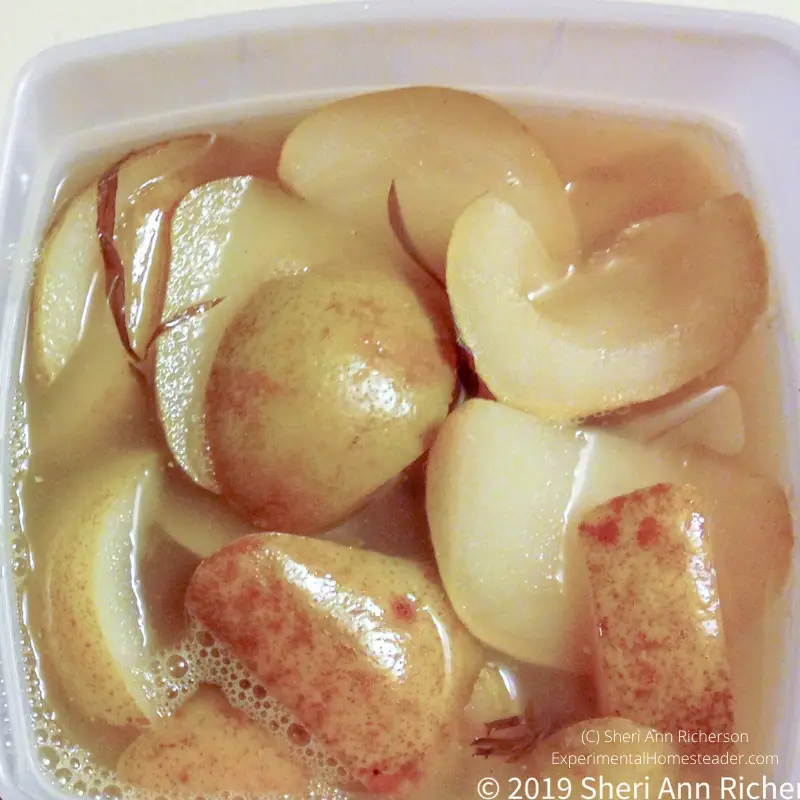 Pears in liquid in freezer containers.
