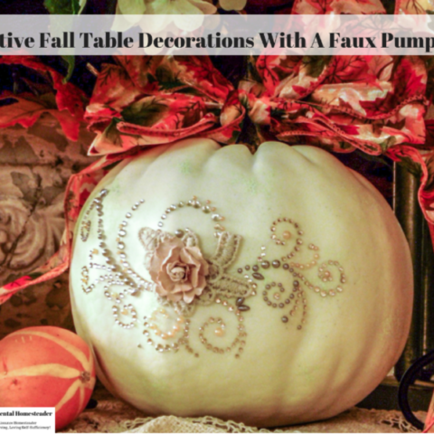 A white pumpkin decorated with a bow and bling.