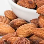 Almonds in a bowl and on a table.
