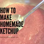 Homemade ketchup in a stainless steel pan being stirred.