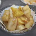 A mini apple pie recipe in a wonton wrapper inside a cupcake wrapper in a muffin tin.