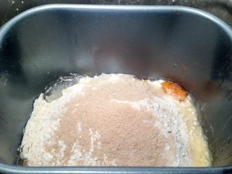 The view inside of the bread maker before it begins mixing the homemade Swerve Dinner Rolls recipe.
