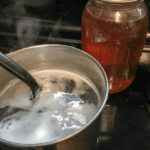 Honey in a quart jar and honey brine in a saucepan.