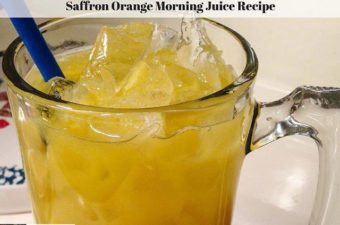 Ice in a glass filled with saffron infused orange juice.