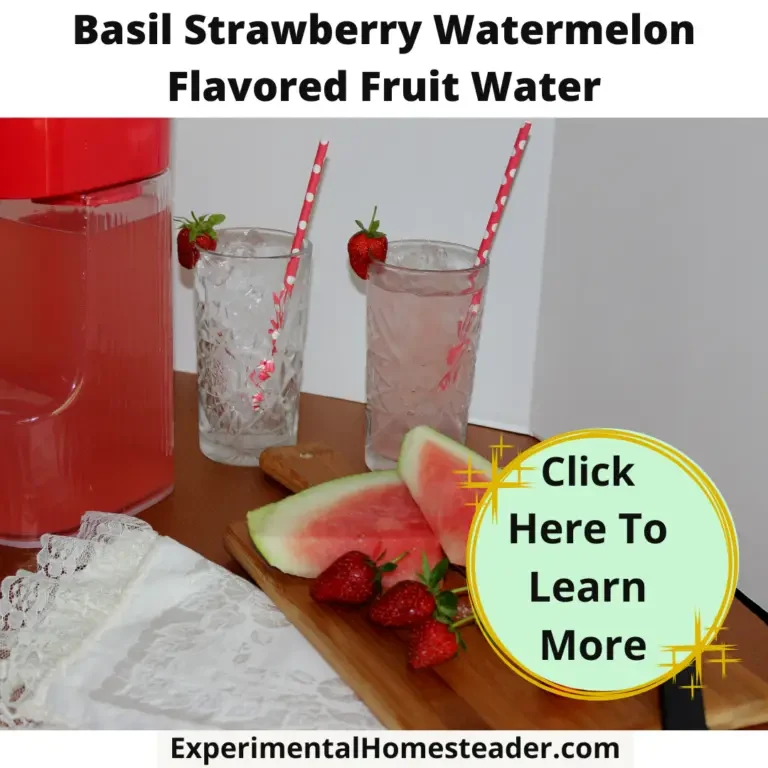 Strawberries, watermelon and basil on a cutting board with a pitcher of fruit infused water and two glasses behind. One glass is filled with ice and some of the fruit flavored water. The other glass is filled with ice.