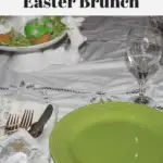 A plate, utensils and a wine glass sitting on a table decorated for Easter.