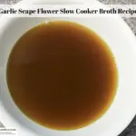 Broth made with garlic scape flowers in a bowl.