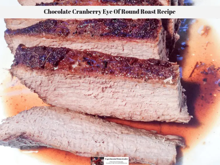 The chocolate cranberry eye of round roast sliced and resting on a plate.