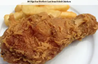 A double fried chicken leg and French fries on a white plate.
