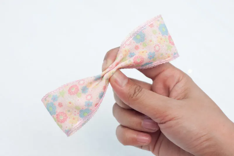 This picture shows the center of the ribbon being pinched together to create the bow.