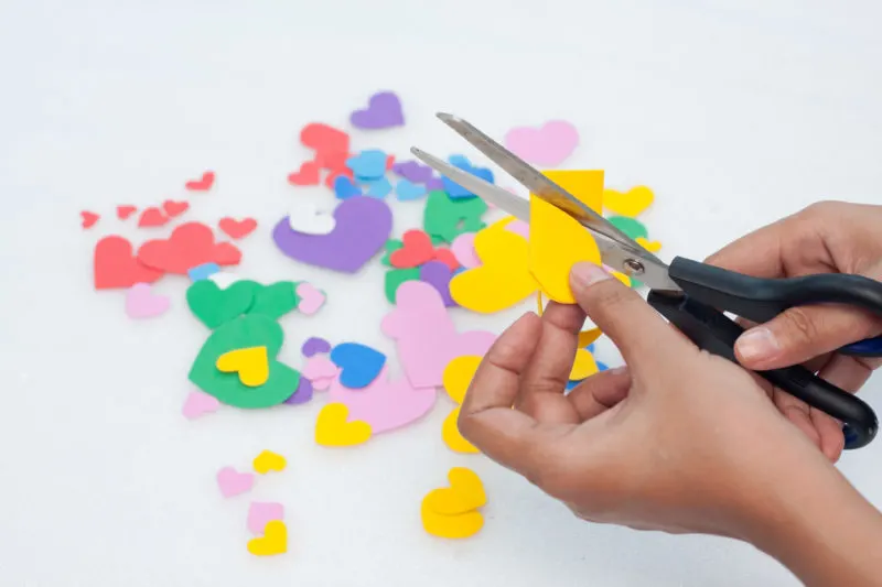 This photo shows the cutting out of multiple colored heart shapes.