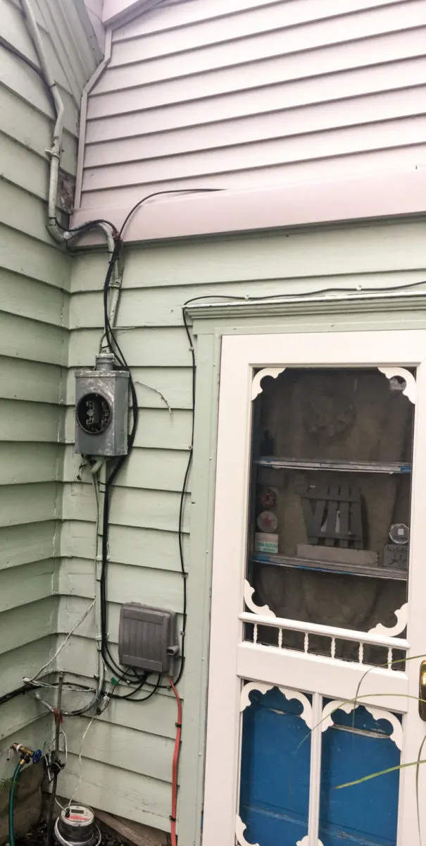 The old meter box and wiring still attached to the outside of the house.