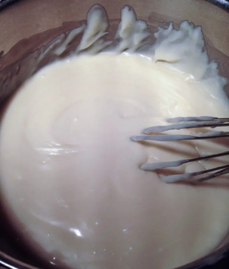 The white chocolate being whisked until it is smooth.