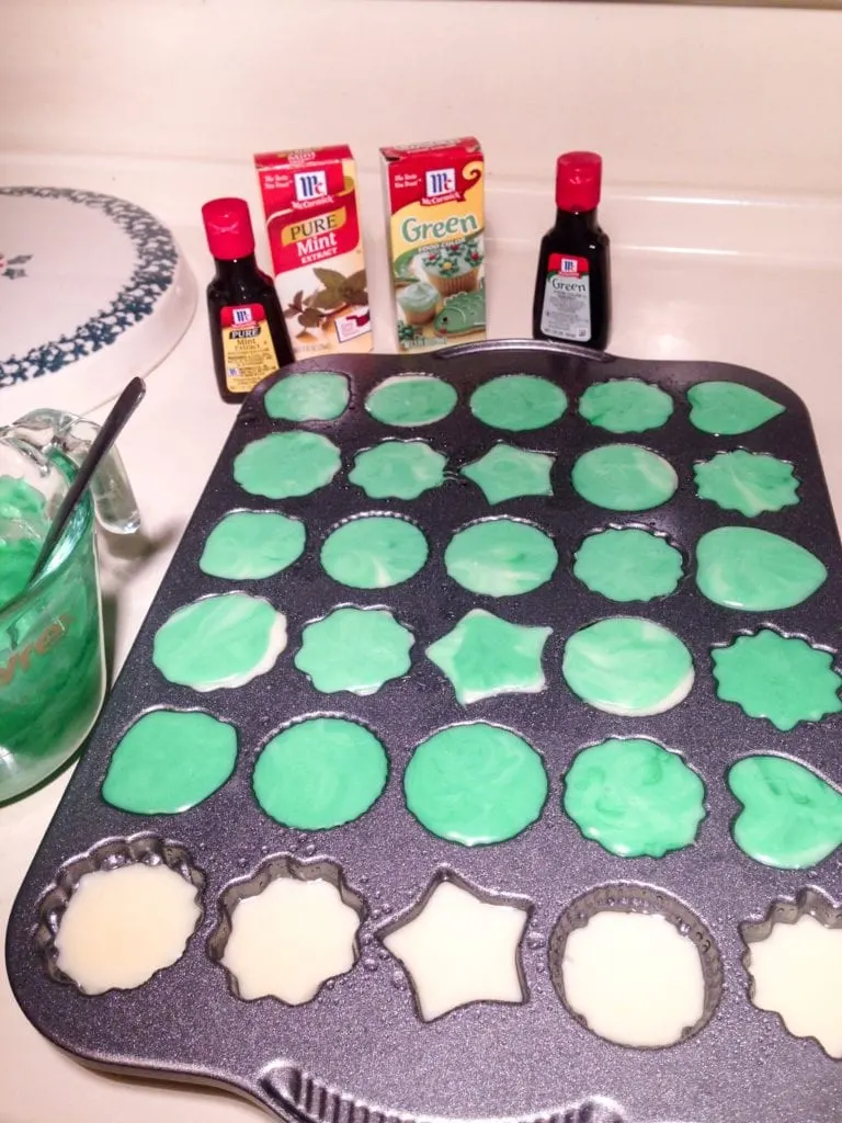 The white chocolate and the green colored white chocolate being added to the pan.