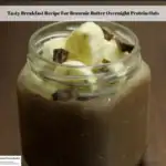 The photo shows the ready to eat Brownie Batter Overnight Protein Oats topped with bananas and dark chocolate chunks.