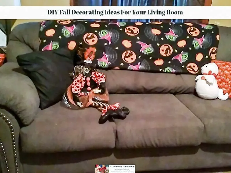 A couch with pillows, plush animals and a throw on the back,.