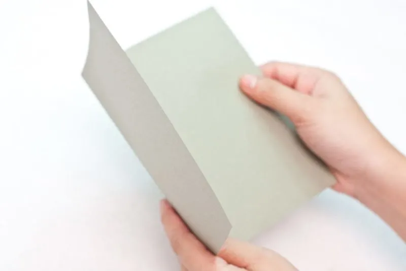 The cardboard being folded to create a card.