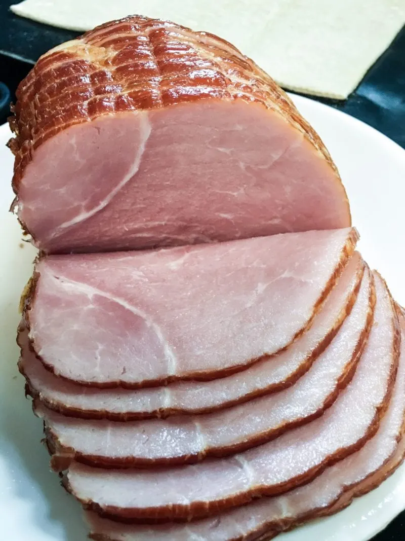 Frick's Quality Meats Applewood Smoked Sliced Ham With Natural Juices on a plate.