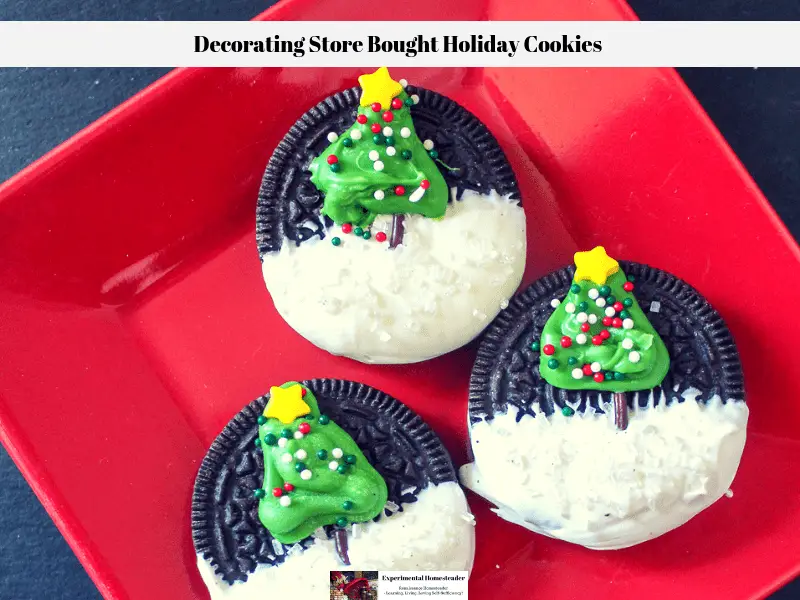 Oreo cookies decorated with a Christmas tree and candy snow on a red plate.