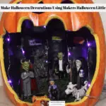 A ready to display Maker's Halloween Littles Jack O'Lantern Container Fairy Garden lit up with purple LED lights.