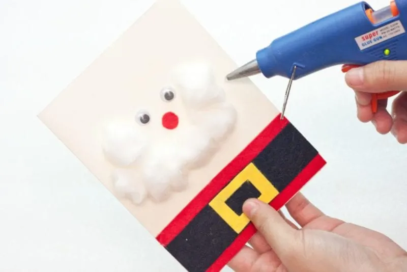 The cotton being glued on to the front of the cute handmade card to make Santa's beard.