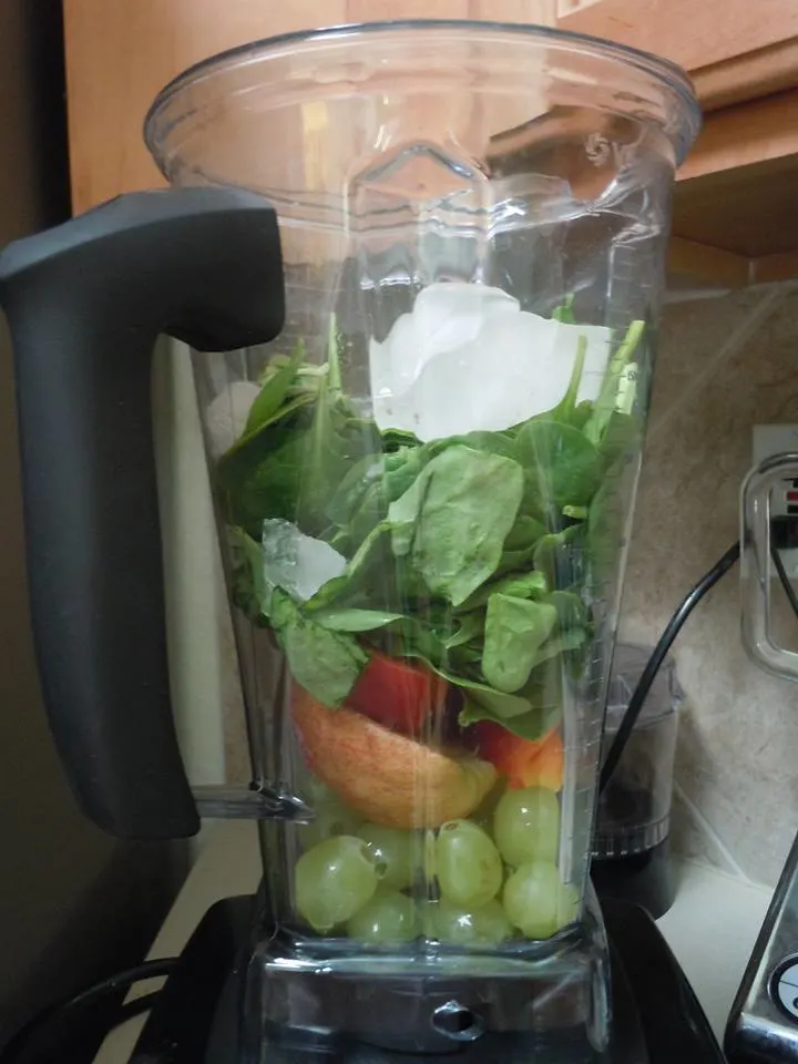 Fruits and spinach in a blender.