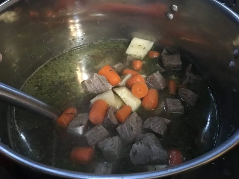 Beef stew being cooked in a stock pot.