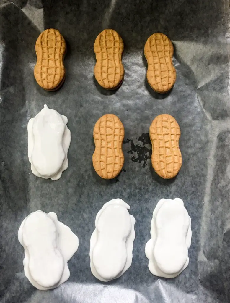 Nutter Butter Cookies being covered in white icing.