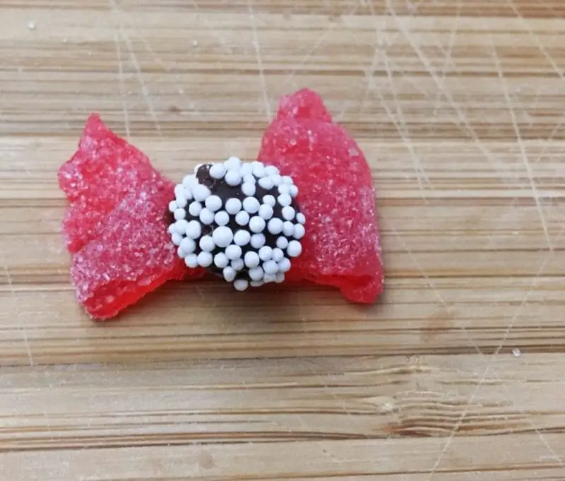 A red spice drop and Sno-Caps Candy bow.