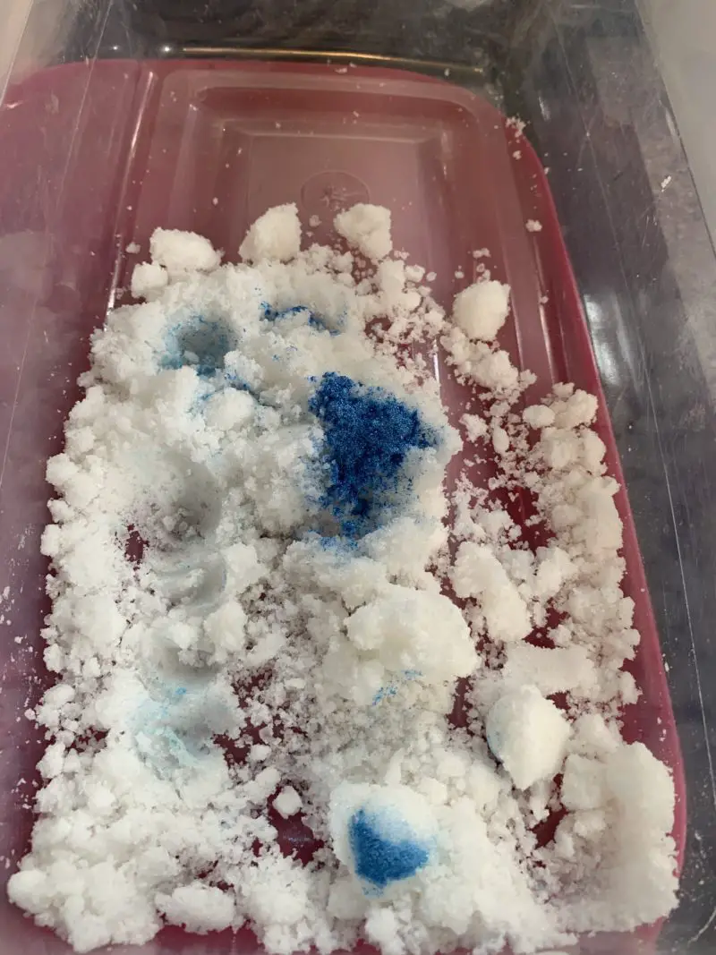 The divided bath bomb recipe with the blue mica powder being added to it.