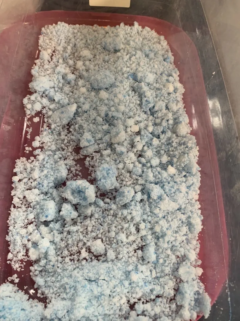 The blue mica powder being mixed into the bath bomb mixture.
