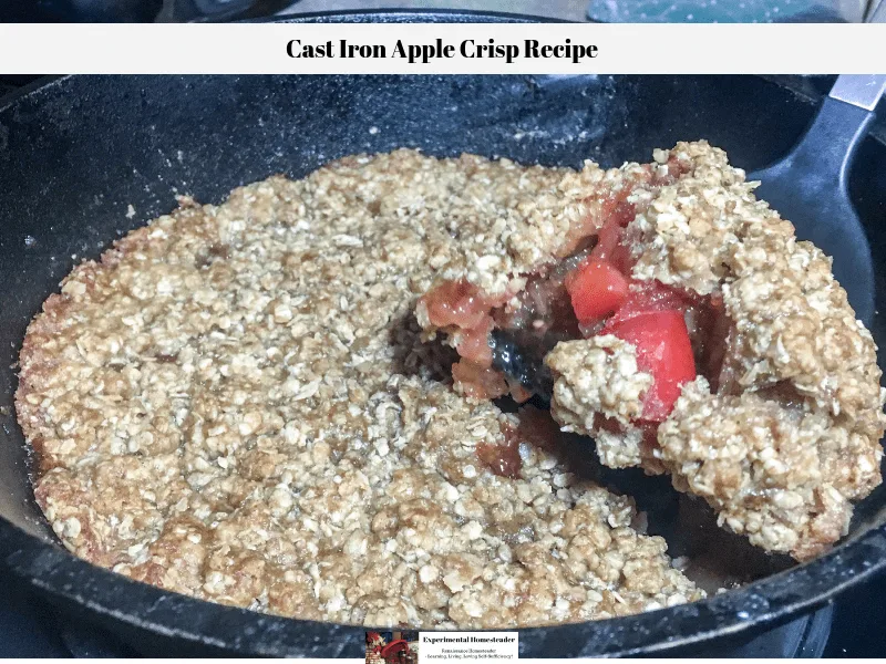 A slice of the apple crisp being removed from the cast iron skillet.