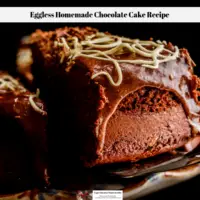 A slice of eggless homemade chocolate cake being removed form the main cake in order to serve it.
