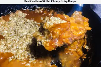 Cherry crisp being dipped out of a cast iron skillet.