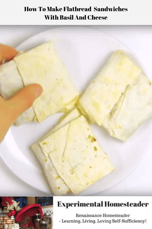 Healthy flatbread sandwiches with basil and cheese being picked up off a plate.