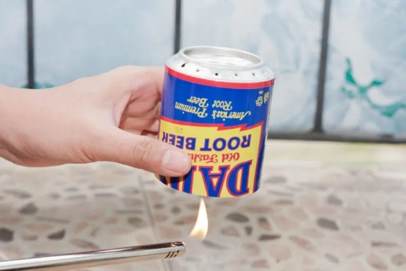 A lighter being used to heat up the bottom of the portable stove.