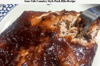The cooked sous vide country style pork ribs with carmalized BBQ sauce on a plate with a fork inserted to break the meat apart.