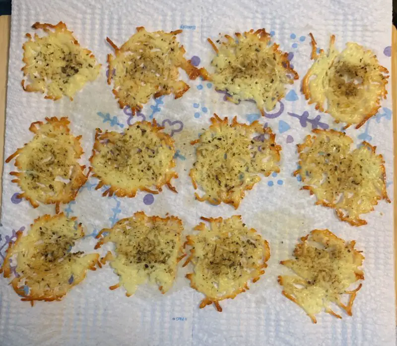 The baked cheese crisps draining on paper towels.