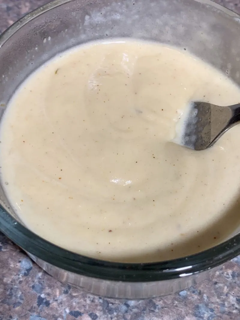 The Wondra flour and the cheese sauce in a small bowl becoming creamy.