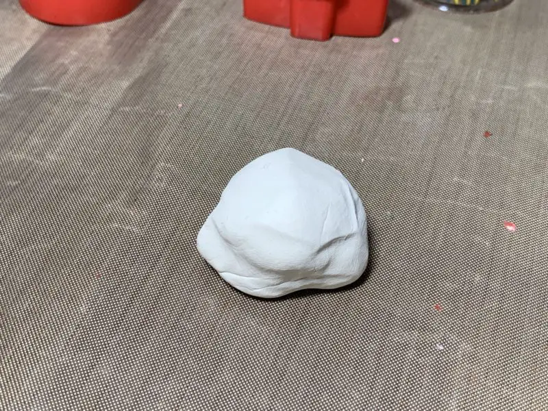 White polymer clay rolled into a ball.