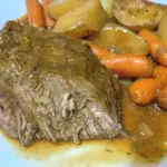 The London Broil, potatoes and carrots on a plate ready to be eaten.