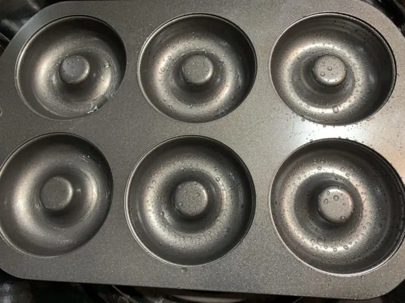 The lightly greased donut pan.