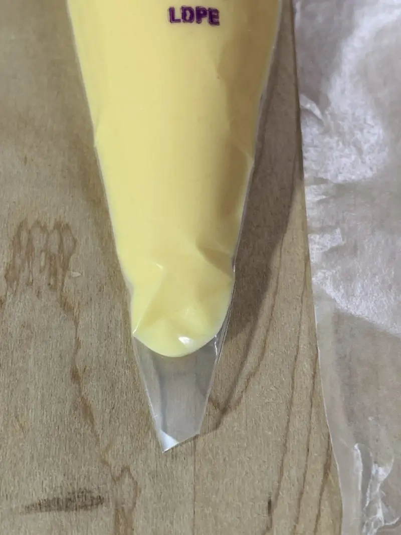 The tip of the piping bag being cut off.