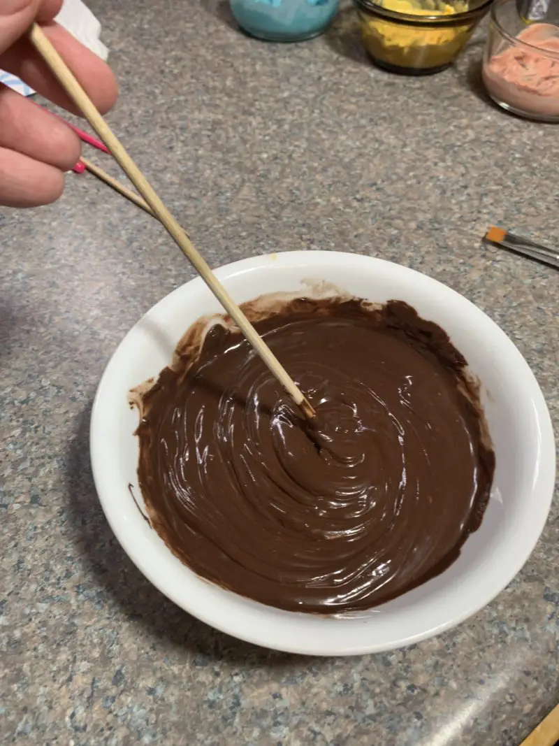 The dark cocoa candy melts being stirred after being melted in the microwave.