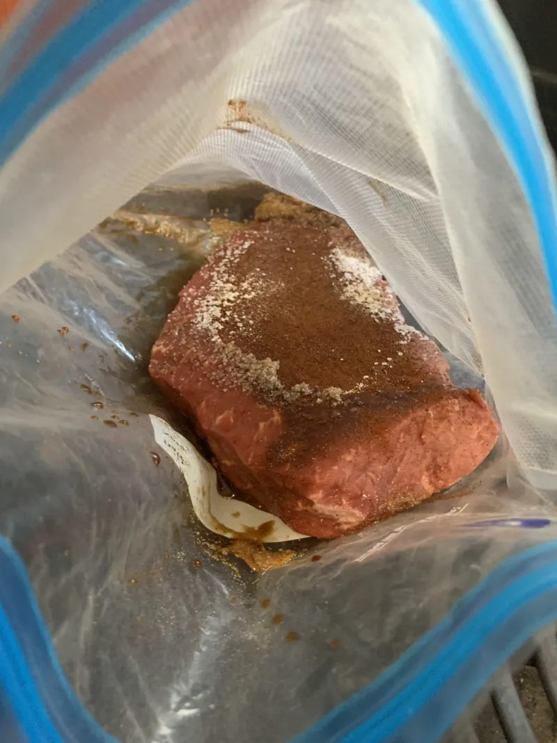 The seasonings being added to the piece of meat inside the Sous Vide Bag.