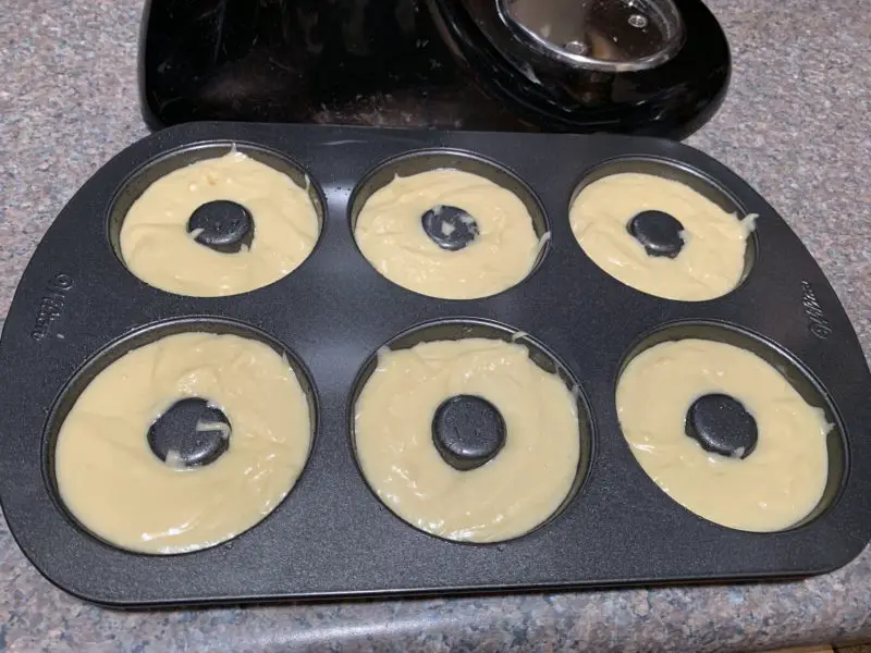 The donut batter in the donut pan.