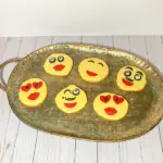 Decorated emoji sugar cookie ideas laid out on a platter.